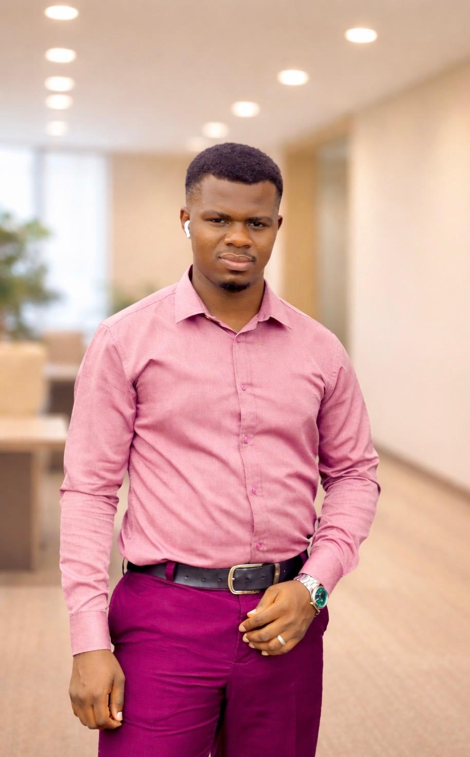 Man wearing a pink shirt and purple pants in an indoor setting